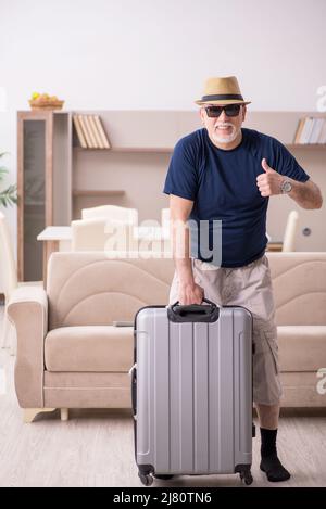 Old male tourist preparing for trip at home Stock Photo