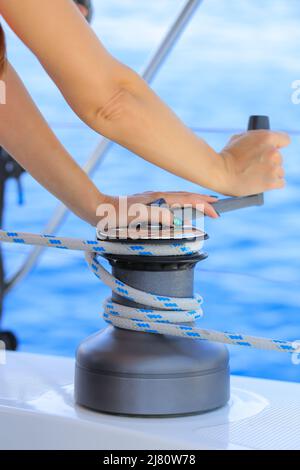 Closeup up of yachtsman hand dealing with yacht ropes on halyard winch Stock Photo