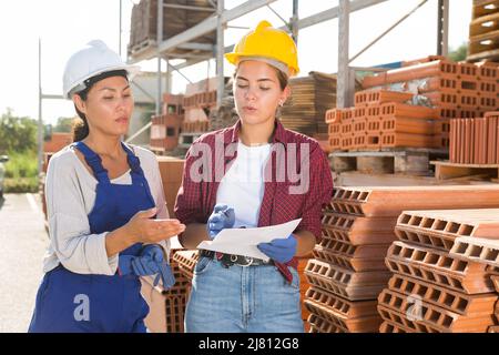 Female workers having conversation in outdoot warehouse Stock Photo