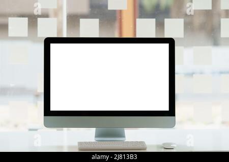 Front view of Mock up desktop computer with blank screen on desk at office. Stock Photo