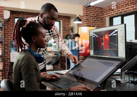 Game developing creative company employee working on videogame level design. Production department 3D artist team leader with multiple displays on desk working on digital entertainment project. Stock Photo