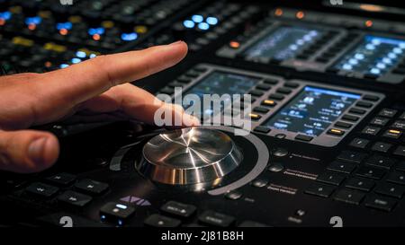 Male hand adjusting the volume on the sound mixing panel Stock Photo