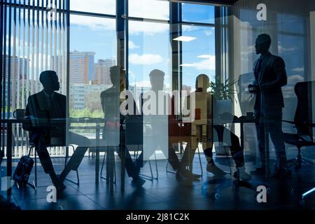 boss afro businessmen talking with arab partners colleague, multiethnic team in the office with panorama window. Stock Photo