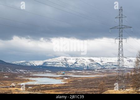 view of a high voltage power line pole against the background of a frosty alpine landscape Stock Photo