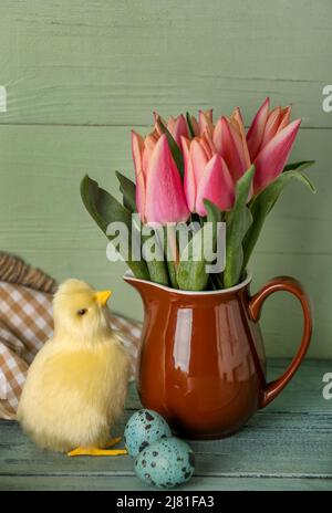 Cute chicken, Easter eggs and tulips on table Stock Photo