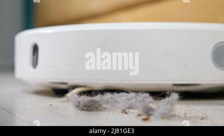Close up of a robot vacuum cleaner driving on the floor Stock Photo