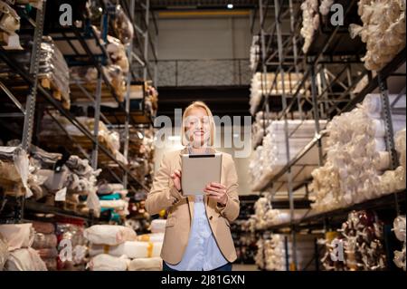 Woman worker working with digital tablet checking boxes Logistic import and export supplies packages in Warehouse , Logistics concept Stock Photo