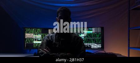 Anonymous hacker in military unifrorm on dark web, cyberwar concept. Stock Photo