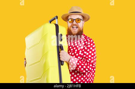 Joyfully funny excited extravagant bearded fat man with suitcase ready for summer vacation. Stock Photo