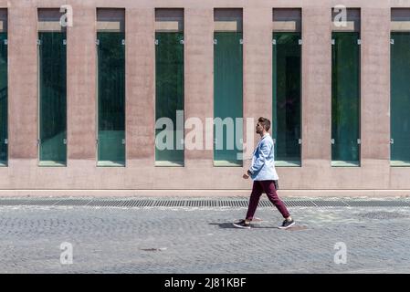 Young urban businessman professional walking in street wearing smart casual jacket. City lifestyle commute person walking. Stock Photo