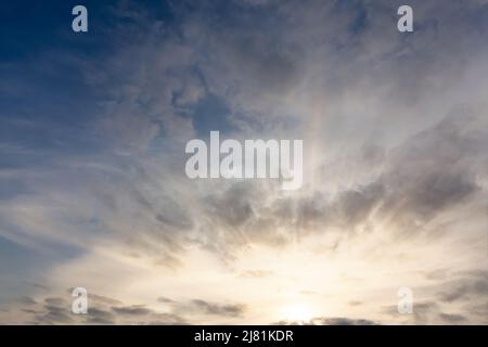 Amazing sunset sky with sunrays and clouds. Sun on the horizon with cloudscape Stock Photo