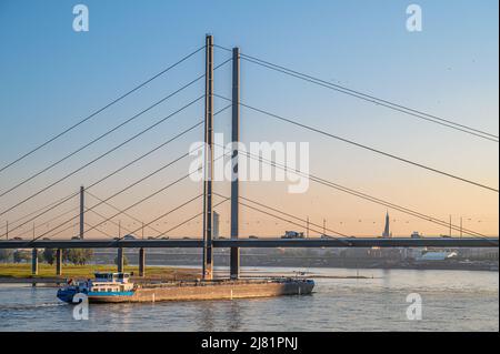 Inland vessel in front of the Duesseldorf Rhine knee bridge at dawn, NRW, Germany Stock Photo