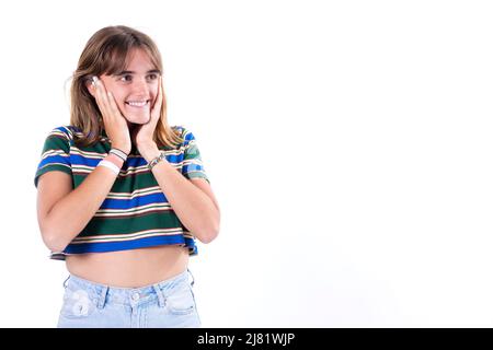 Waist up portrait of a happy attractive girl holding her hands on her neck, smiling and looking at the camera isolated over white background Stock Photo