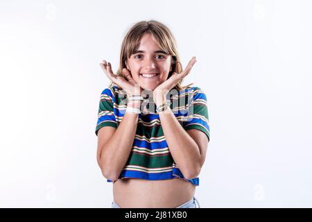 Waist up portrait of a happy attractive girl holding her hands on her neck, smiling and looking at the camera isolated over white background Stock Photo