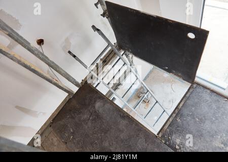 Ladder on scaffolding on site from above inside new house Stock Photo