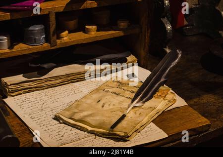 Recreation of an antique desk with a quill on parchments Stock Photo