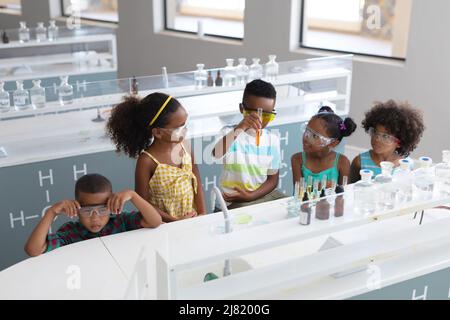 African american elementary school students performing chemical experiment in laboratory Stock Photo