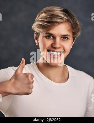 young smiling handsome guy showing Ok gesture Stock Photo