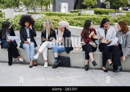 Multiethnic business women doing lunch break outdoor from office building - Focus on muslim girl face Stock Photo