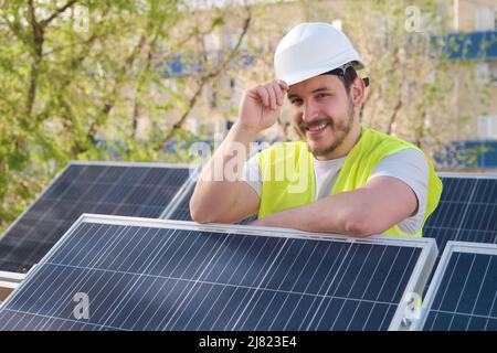 Solar panels technician looking at camera after installing photovoltaic station. Stock Photo