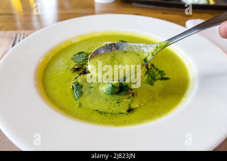 Broccoli cream soup in white plate on wooden background Stock Photo
