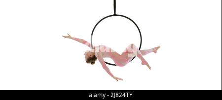 Portrait of young sportive girl, air gymnast performing on hoop isolated over white studio background. Flyer image Stock Photo