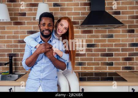 caucasian redhaired woman and afro male having breakfast at home Stock Photo