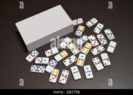 Blank box and dominos on black table Stock Photo