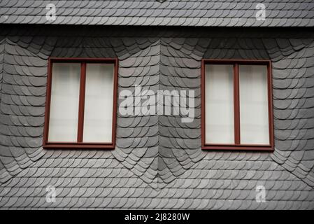 Two wiindows surrounded by many slate/stone plates against weathering. Building in Frankfurt am Main, in Germany. Stock Photo
