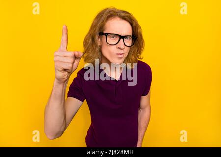 Photo of sad young red hairdo guy index wear eyewear purple polo isolated on yellow color background Stock Photo