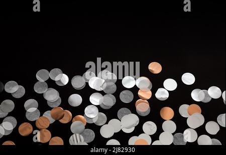 silver, gold, white confetti dots on black background.  glitter confetti background Stock Photo