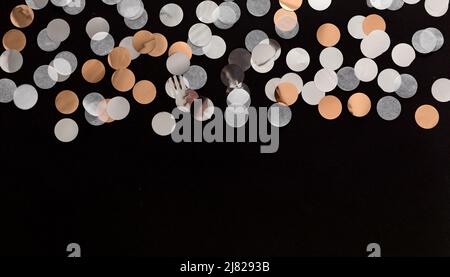 silver, gold, white confetti dots on black background.  glitter confetti background Stock Photo