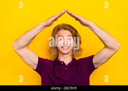 Photo of impressed young ginger guy arms roof wear violet t-shirt isolated on yellow color background Stock Photo