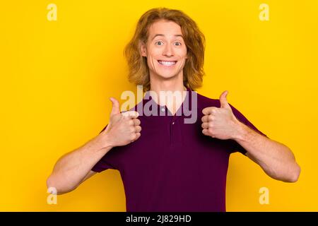 Photo of impressed young ginger guy thumb up wear violet t-shirt isolated on yellow color background Stock Photo