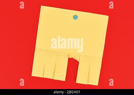 Empty yellow tear-off stub paper note without text on red background Stock Photo