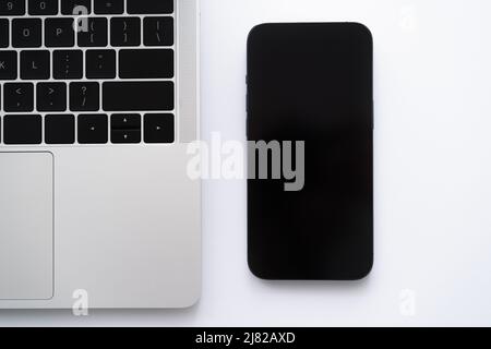 top view of smartphone with blank screen near laptop on white Stock Photo