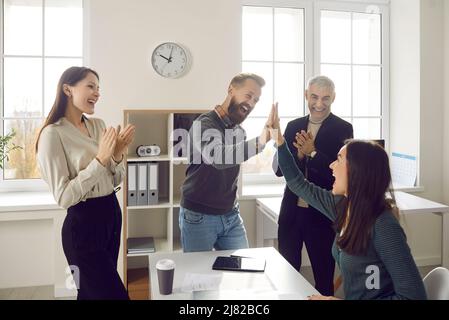 Happy employees give high five celebrate success Stock Photo