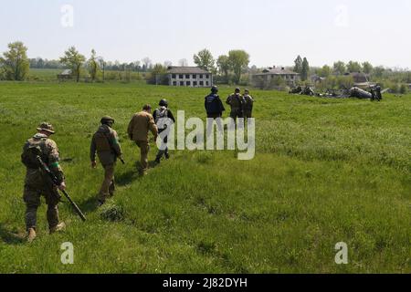 Biskvitne, Ukraine. 08th May, 2022. War Crimes prosecutor and Ukrainian soldiers walk to a destroyed Russian helicopter shot down by Ukrainian anti-aircraft in the Biskvitne village. Ukrainian soldiers liberated the small village of Biskvitne outside of Kharkiv were Russian troops recently withdrew following intense fighting with Ukrainian forces. Russia invaded Ukraine on 24 February 2022, triggering the largest military attack in Europe since World War II. Credit: SOPA Images Limited/Alamy Live News