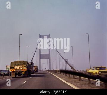 The Severn Bridge in 1976. This bridge crosses over the River Severn and connects England and Wales. This image is a photograph taken from the original slide. Stock Photo