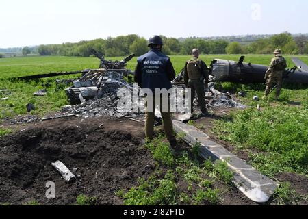 Biskvitne, Kharkiv, Ukraine. 8th May, 2022. War Crimes prosecutor inspect a destroyed Russian helicopter shot down by Ukrainian anti-aircraft in the Biskvitne village. Ukrainian soldiers liberated the small village of Biskvitne outside of Kharkiv were Russian troops recently withdrew following intense fighting with Ukrainian forces. Russia invaded Ukraine on 24 February 2022, triggering the largest military attack in Europe since World War II. (Credit Image: © Salvatore Cavalli/SOPA Images via ZUMA Press Wire)