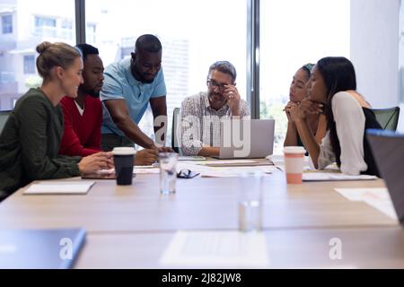 Multiracial businessmen and businesswomen discussing strategy during meeting in boardroom at office Stock Photo