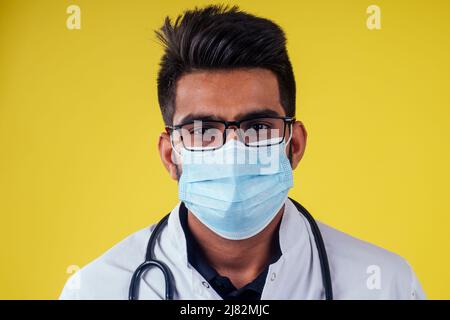 Young male doctor on yellow background in studio Stock Photo