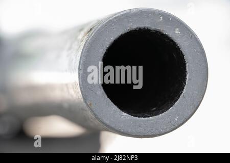 The barrel of the cannon aims front into a camera, on a white background Stock Photo