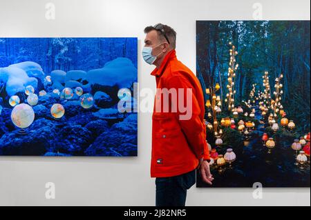 London, UK.  12 May 2022. A man passes works on show on the opening day of Photo London at Somerset House.  The annual photography fair celebrates photography from the vintage to modern alongside a selection of the world’s leading photography dealers and galleries.  A public programme of talks, tours and more run throughout the show 12 to 14 May 2022.  Credit: Stephen Chung / Alamy Live News Stock Photo