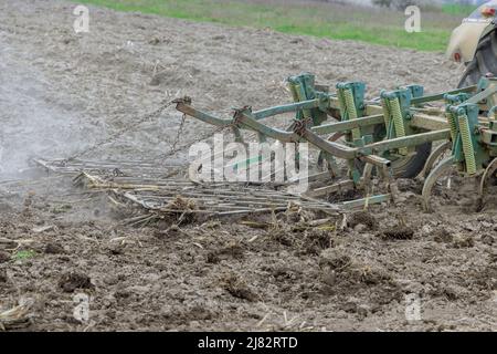 Tractor crushes soil for ready to sowing crops. Stock Photo