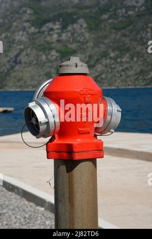 A new red fire hydrant by the sea in Montenegro. Stock Photo