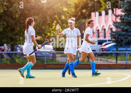 Field hockey team players cheer each other with success attack and goal score Stock Photo
