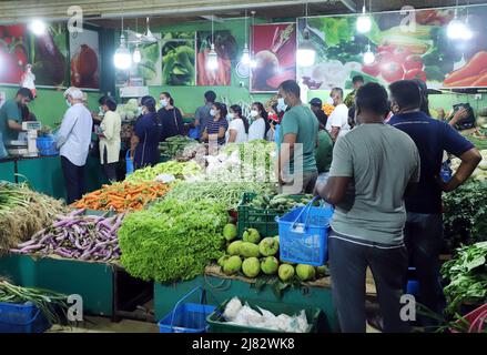 Colombo, Sri Lanka. 12th May, 2022. People buy vegetables from a market after the authorities relaxed the curfew for a few hours in Colombo, Sri Lanka, May 12, 2022. Sri Lanka imposed a nationwide curfew following violent clashes in the capital Colombo on May 9. Credit: Ajith Perera/Xinhua/Alamy Live News Stock Photo