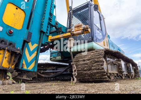 mechanical hammer of a pile driver standing on a technological surface, selective focus Stock Photo