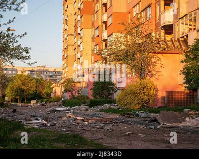 Kharkiv, Kharkov, Ukraine - 05.07.2022: ruined empty street with metal fragments of military weapon wreckage of building bombed house civilian Stock Photo